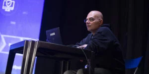 Sergio Loiacono Sr. Sales Engineer di Proofpoint mentre sta pilotando il videogioco per lo speech "Proteggersi nell'ombra: dove realtà e inganno si confondono".