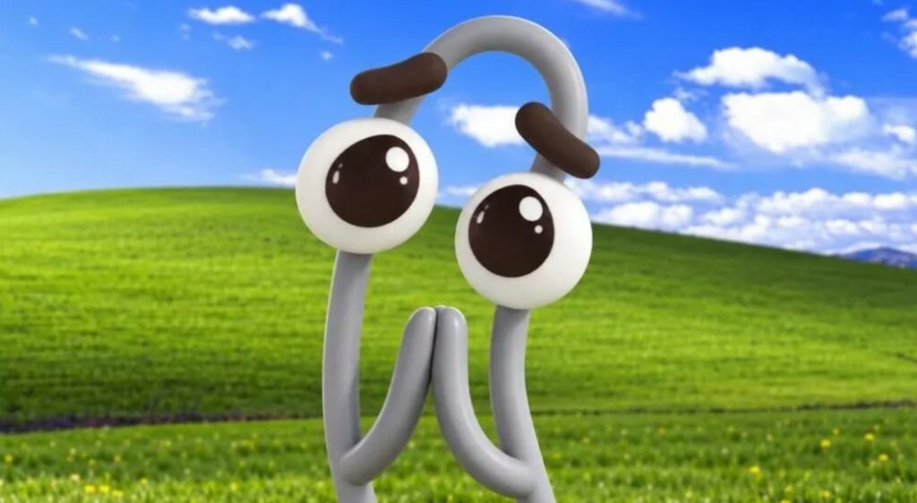 Cartoon di Clippy con espressione sorpresa, cielo azzurro e campo verde